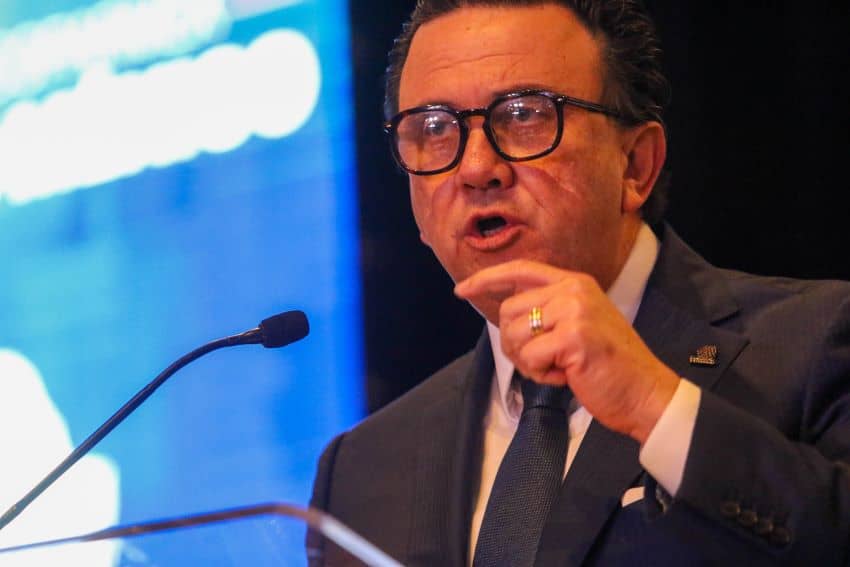 Coparmex business organization leader Juan José Sierra Álvarez standing at a podium with a microfone and pointing his finger emphatically as he speaks. He