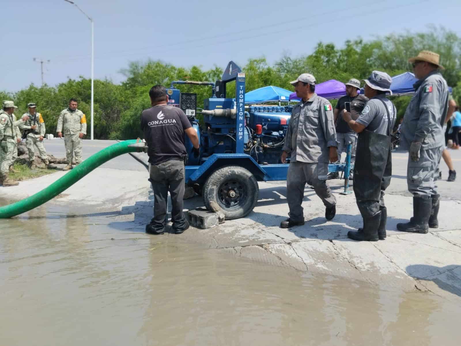 Workers for disaster relief agency clear floodwaters in Reynosa