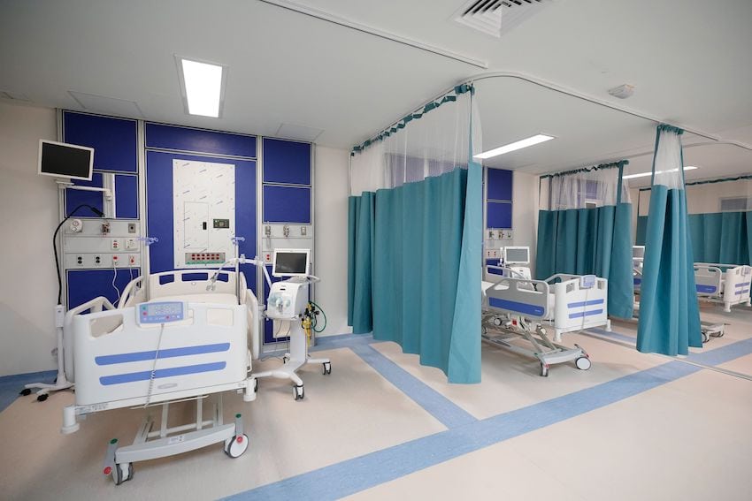 Barrio del Hospital IMSS en Juchitan, Oaxaca, con tres puestos vacíos con camas de hospital y equipos médicos.