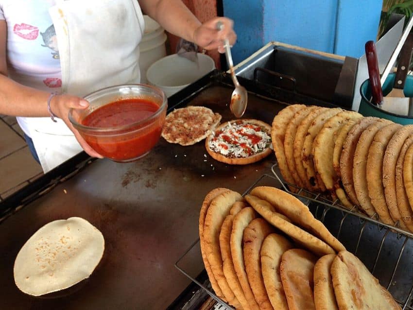 El vendedor callejero prepara a Gorditas fritas en una plancha