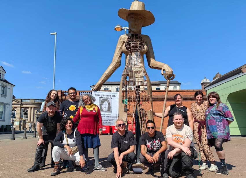 Pesrons sentados alrededor de una estatua alta