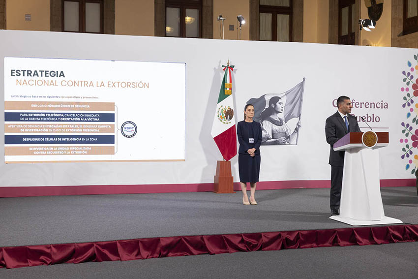 El presidente Sheinbaum observa como el ministro de seguridad García Harfuch comparte una presentación sobre la estrategia nacional contra la extorsión en una conferencia de prensa