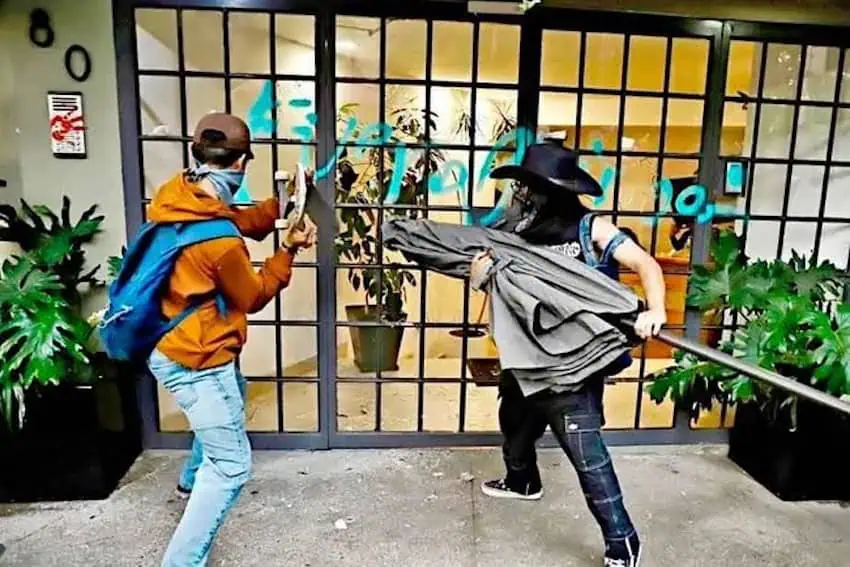 anti-gentrification protesters in Mexico City smash a window