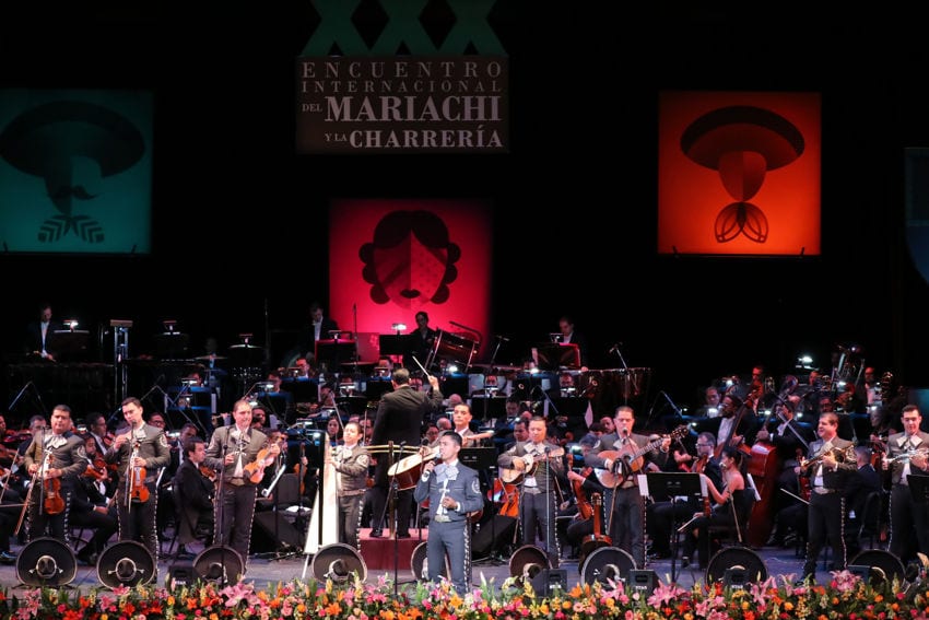 Los músicos mariachi actúan junto con una orquesta en un escenario en el Festival Internacional Mariachi y Charrería en Guadalajara