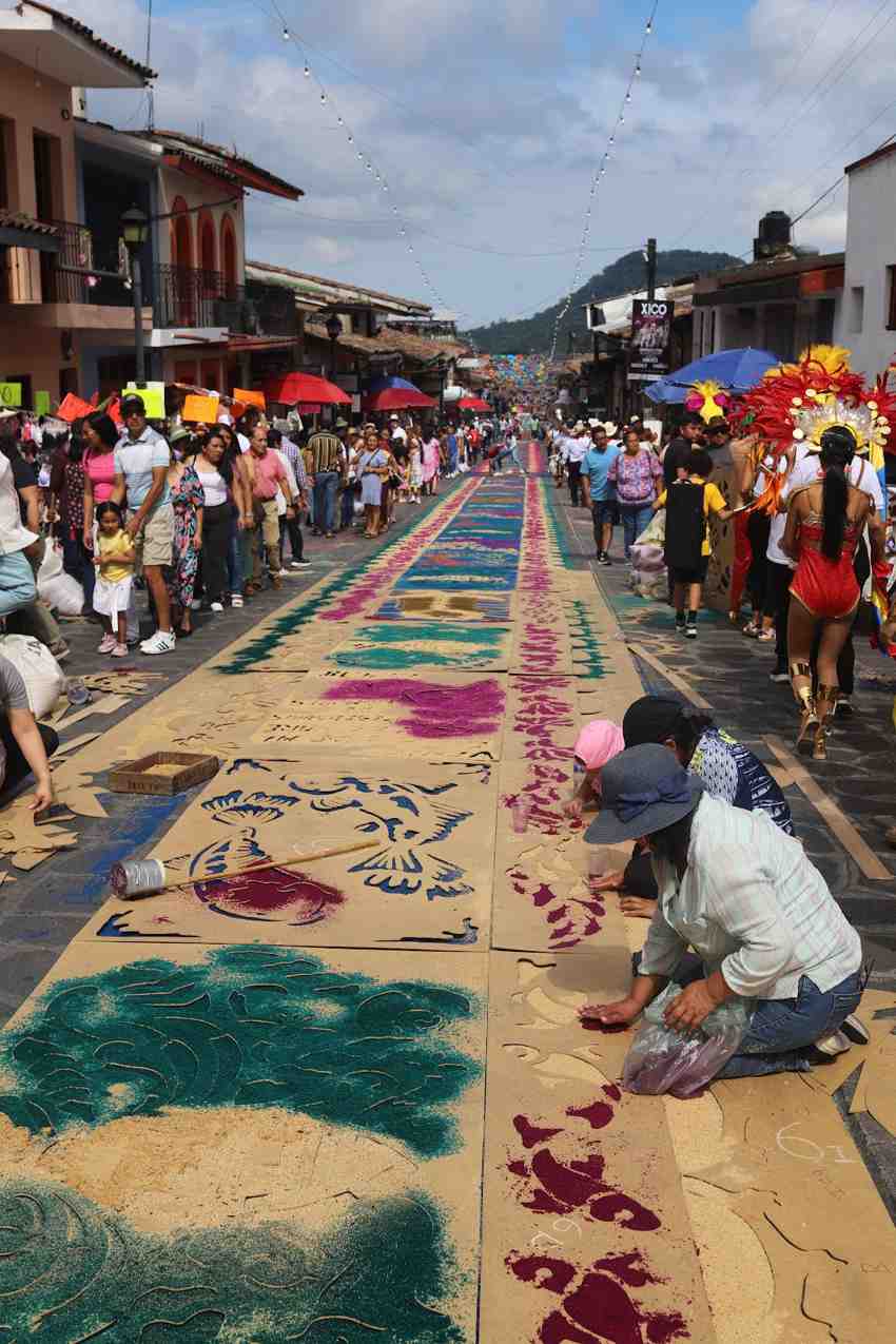 Los miembros de la comunidad crean elaborado "tapetes" - Alfombras de aserrín coloridas con intrincados patrones florales y geométricos - estirando por la calle principal de Xico durante el Festival de La Xiqueñada.