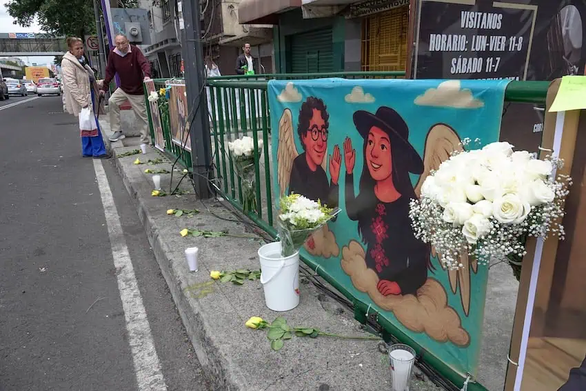 A streetside altar in Mexico City with flowers and a banner honoring two aides to Mayor Clara Brugada who were killed in May