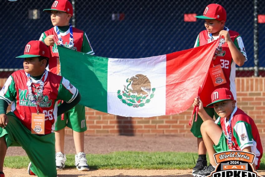 niños en uniforme de béisbol sosteniendo bandera