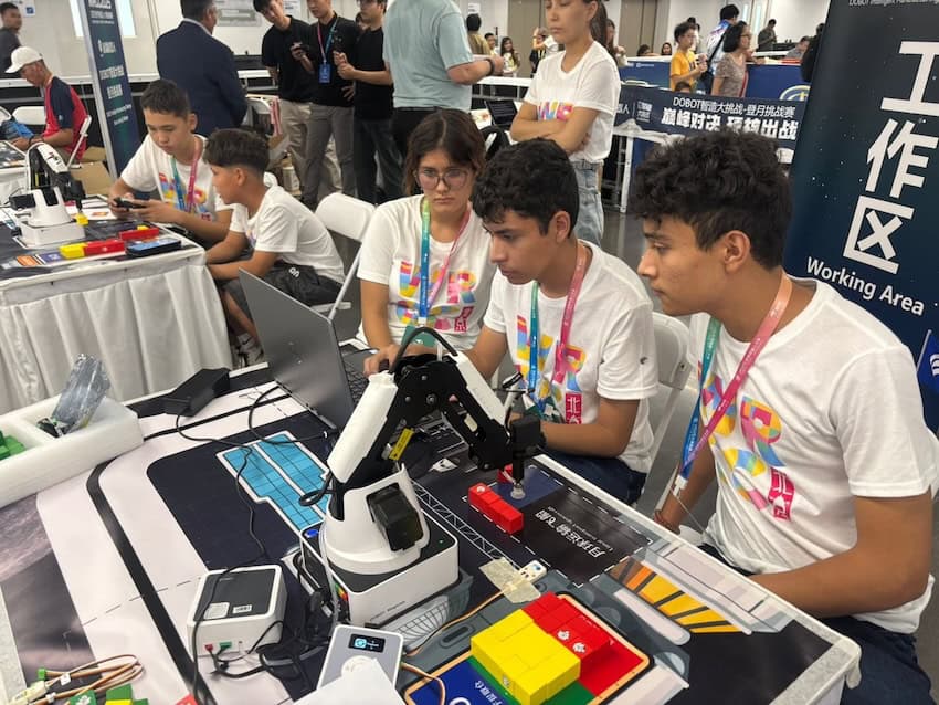 Karina Jaired Castellanos Hernández, Gabriel Enrique Ojeda Carrillo y Luis Fernando Quintana Ríos trabajando en su proyecto para el "Desafío de fabricación inteligente de Dobot - Luna Landing Challenge" en el concurso robótico mundial de 2025 en Beijing la semana pasada.