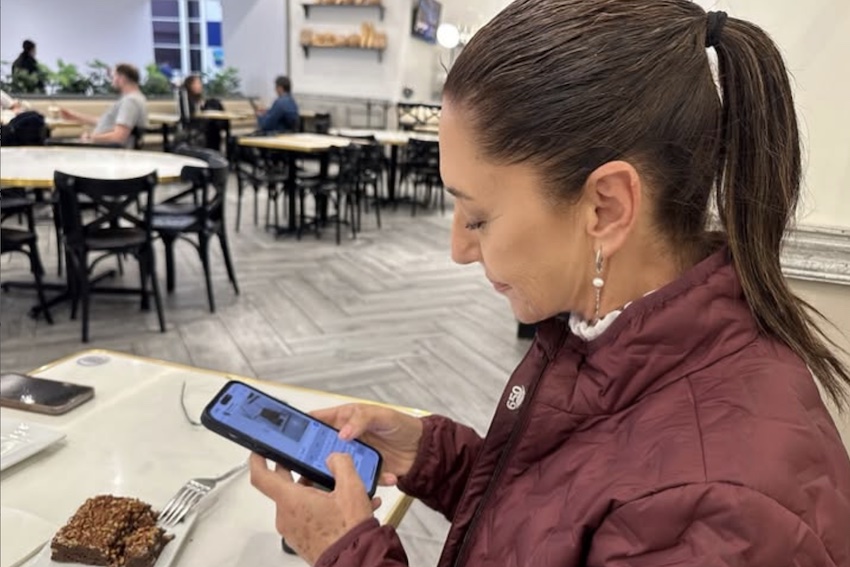 Sheinbaum leyendo algo en su teléfono celular