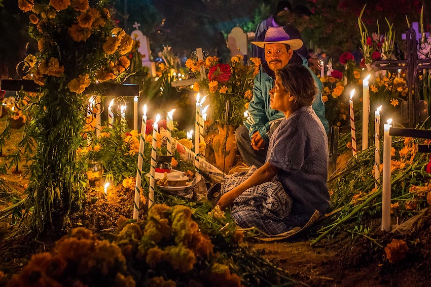 An elderly couple at a grave during Day of the Dead in Oaxaca