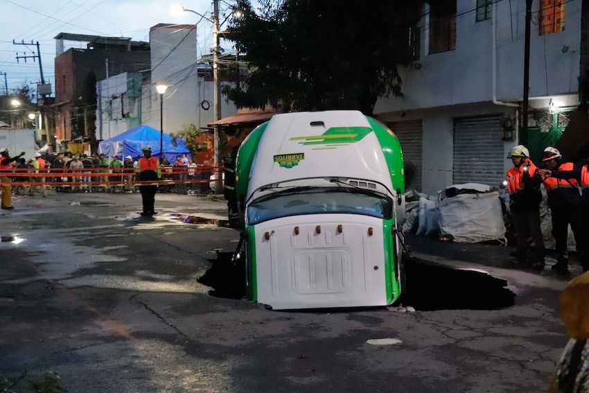 Jarritos truck sticks out from a sinkhole on a street in Mexico City
