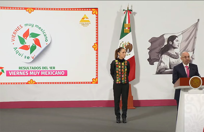 Sheinbaum se encuentra junto a una proyección de una pegatina Viernes muy mexicano en una conferencia de prensa