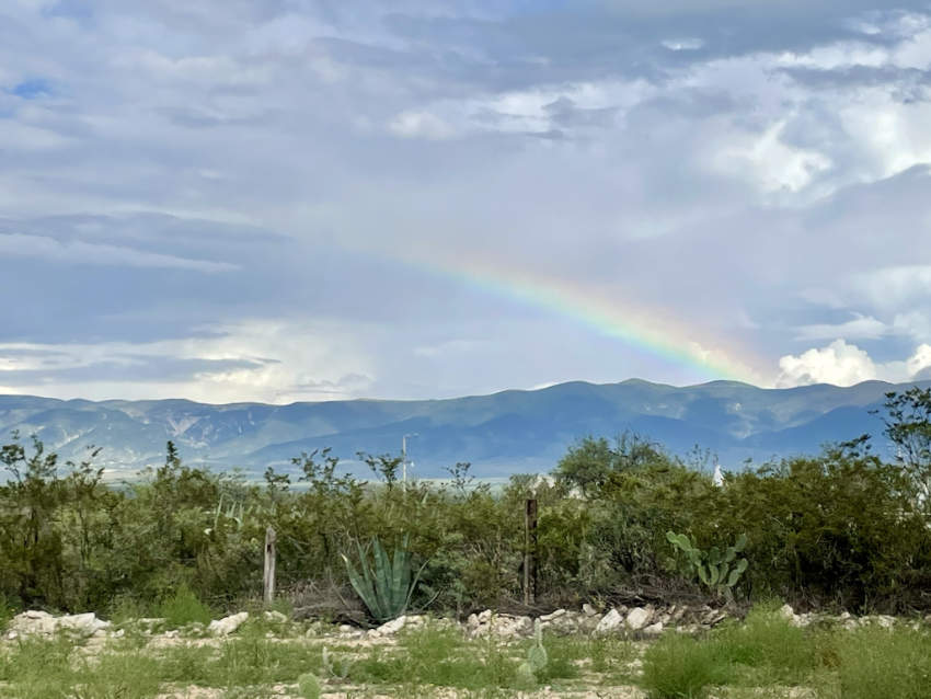 Un arco iris forma un arco sobre las montañas y la flora del desierto, incluidos agaves y cactus, en la tierra sagrada de Wirikuta en San Luis Potosí, México.