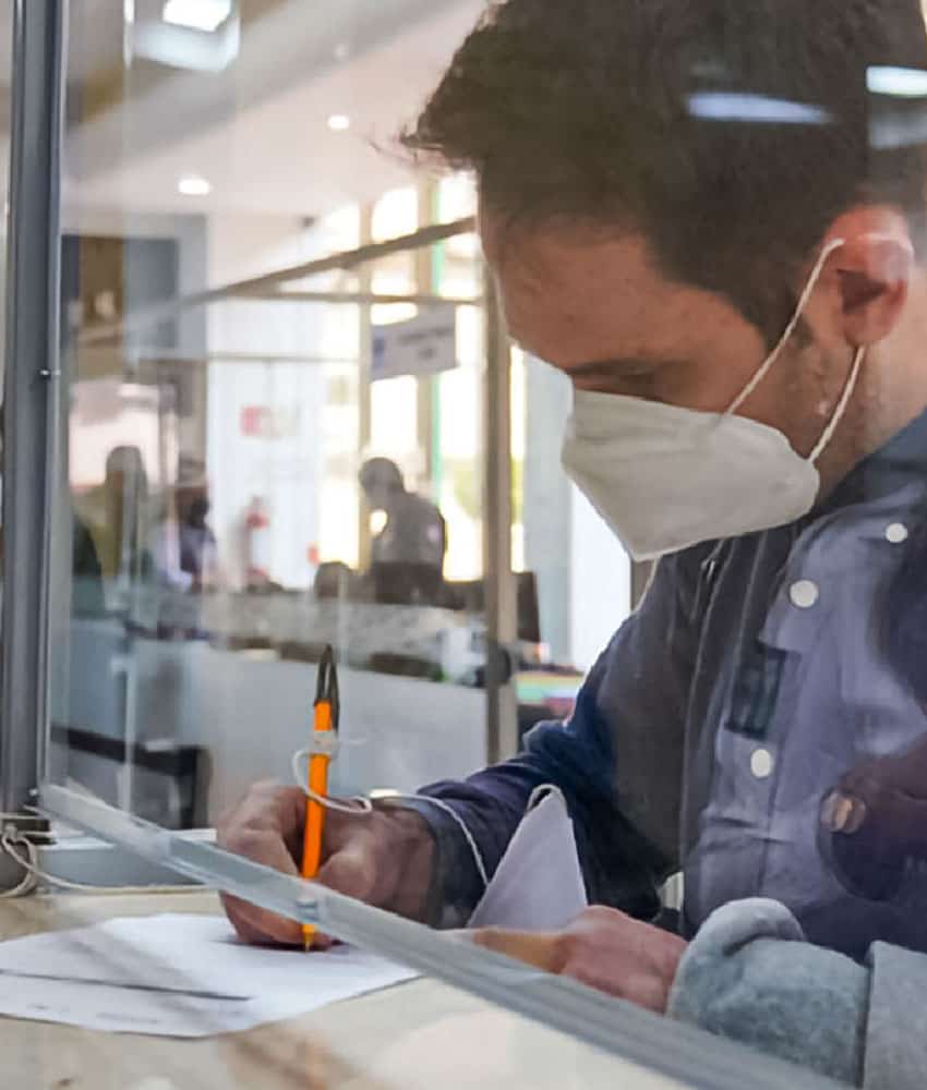 Hombre llenando trámites en la oficina del Instituto Nacional de Migración de México