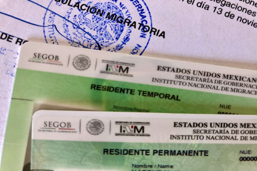 A close-up of two Mexican residency cards: a