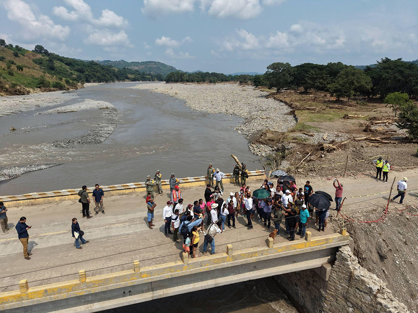Un grupo de políticos se encuentra en un puente sobre el río Pantepec en Veracruz.