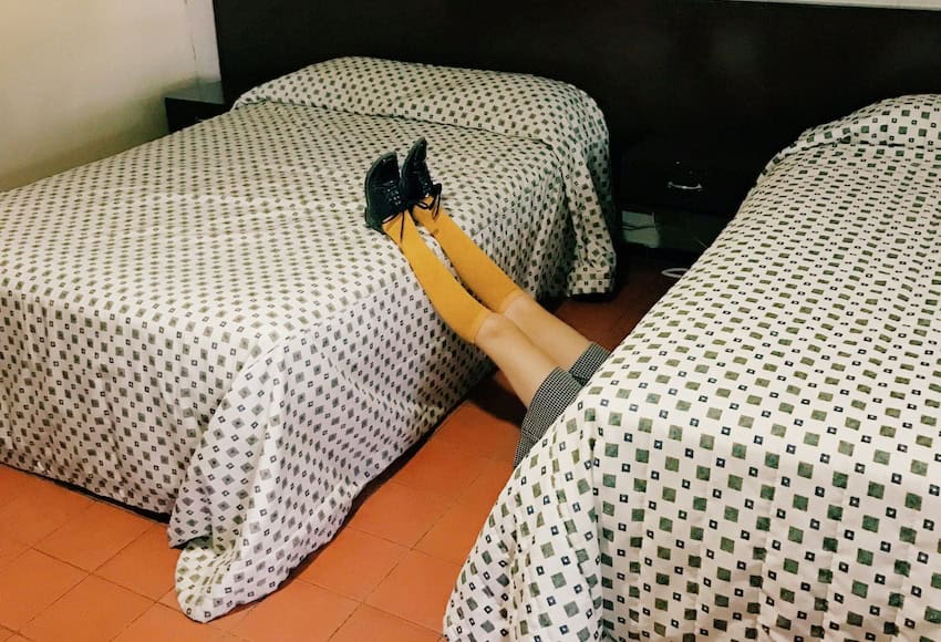 Un hombre durmiendo en el suelo de una habitación de motel.