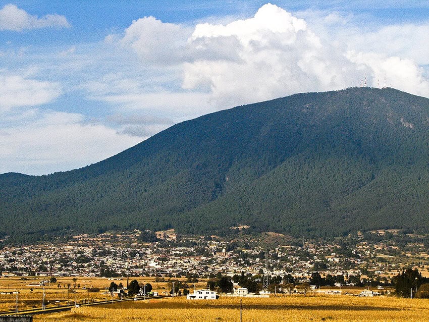 Un pueblo se asienta a los pies de un volcán verde