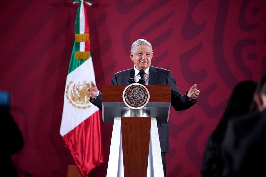 El expresidente de México, Andrés Manuel López Obrador, en una conferencia de prensa en el palacio presidencial de la Ciudad de México. Está parado en el podio presidencial y hablando con los periodistas con los brazos abiertos a ambos lados.