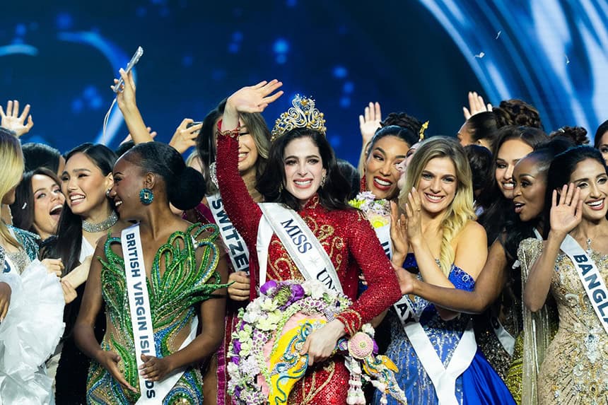 Miss Universo Fátima Bosch saluda a la cámara mientras lleva una corona rodeada de otras concursantes del certamen.