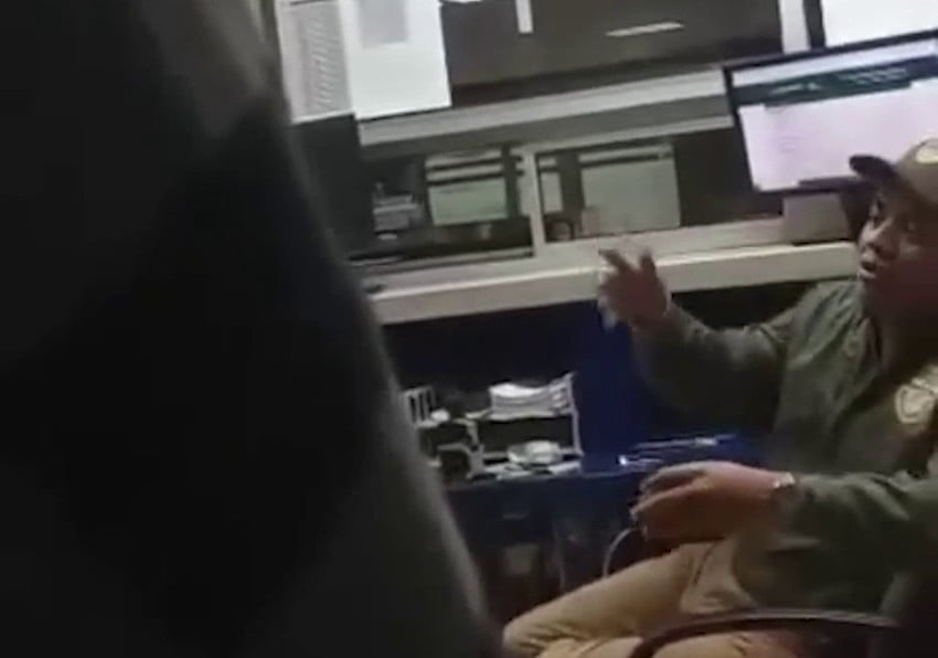 A customs agent gestures in a blurry video screenshot