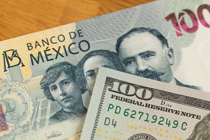 Un billete de 100 dólares y un billete de 100 pesos mexicanos.