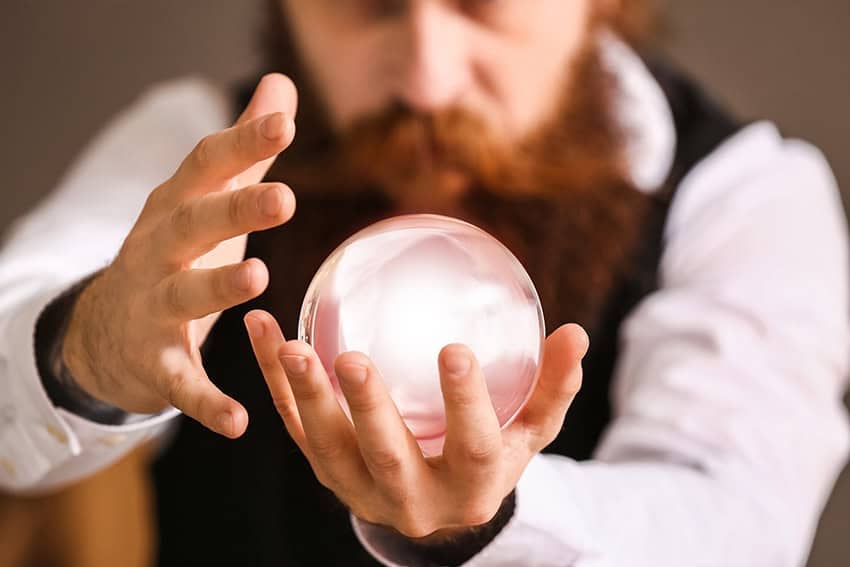 A bearded man stares into a crystal ball