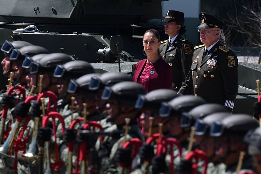 Sheinbaum and two Mexican generals observe a military band on Army Day in Puebla